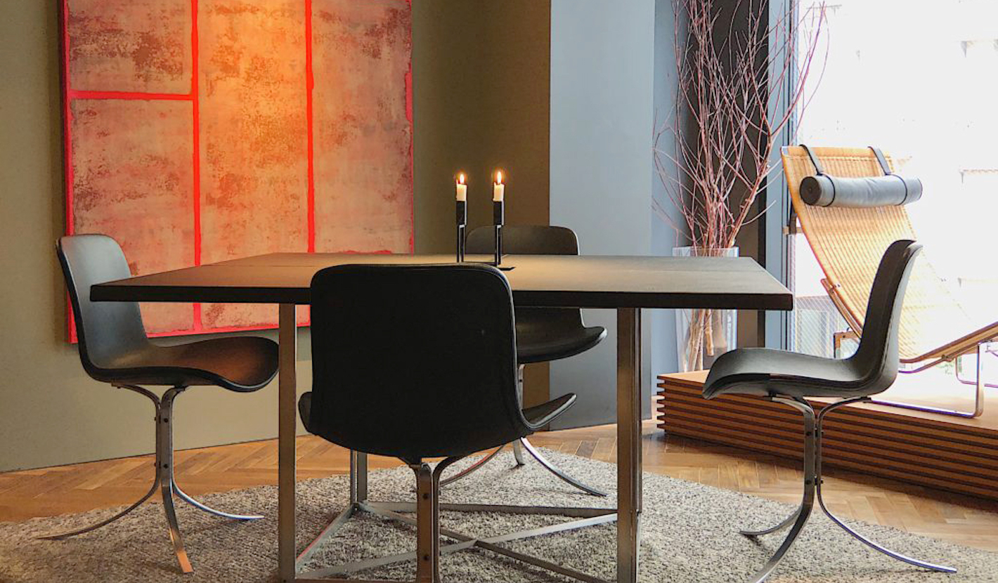 ポール・ケアホルムのレザー仕上げのテーブルに、椅子4脚をゆったりと合わせたレイアウト。テーブルの大きさは140cm×140cmと大ぶり。当初ケアホルムは8人掛けの会議用のテーブルとしてデザインしたと言われている。