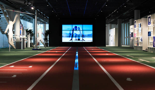 「アシックススポーツミュージアム」1階アスリートフィールド<br>正面がスーパービジョン（138インチ）