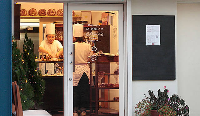 ブーランジェリー ニコラ｜閑静な住宅街のなかにある、こじんまりとした店舗。間口は小さいが、奥の作業スペースは広い。赤いテントを目印に