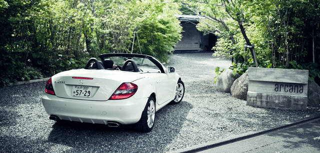 <b>Mercedes-Benz｜メルセデス・ベンツ SLK</b>　生い茂る緑に導かれるようにSLKを滑り込ませ、エントランスへと向かう。宿泊、温泉、そしておいしい食事が楽しめる、伊豆・湯ヶ島の『arcana izu』は、打ちっぱなしのコンクリートの建物が印象的なモダンなつくりのオーベルジュだ。