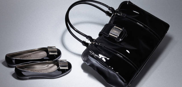<b>Salvatore Ferragamo｜サルヴァトーレ フェラガモ</b>　つややかに光るパテントレザーは、普段の着こなしをワンランクアップして見せてくれる。フロントにあしらわれたヴァラのモチーフがポイント。内側は間仕切りがあり、機能性も抜群。バッグ[W35×H24×D13cm] 16万2750円、フラットシューズもトゥの部分にはシルバー色の金具でヴァラのプレートがあしらわれてシャープな印象に。カーフのパテントレザーを使用。フラットシューズ[H1cm] 5万4600円（ともにサルヴァトーレ フェラガモ／フェラガモ・ジャパン）