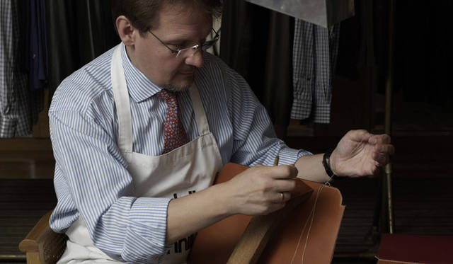 <strong>dunhill</strong> Securing the leather with wooden clamps before stitching.