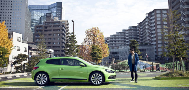 <strong>Scirocco｜シロッコ</strong> 　グリーンを基調とした駐車場のグラフィックも団塚氏によるもの。奥に見える小高い丘は子どもが遊ぶためのキッズパーク。