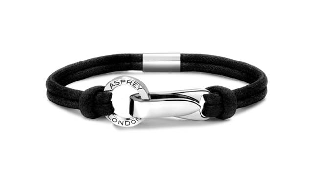 <strong>Asprey｜アスプレイ</strong>　デイリーに使いたいカジュアルジュエリーながら、クラスプの流麗で端正なデザインにアスプレイらしいエレガンスを感じる。「Aライン リストバンド」 [シルバークラスプ×ブラックコットンコード] 8万円（アスプレイ／アスプレイ ジャパン）