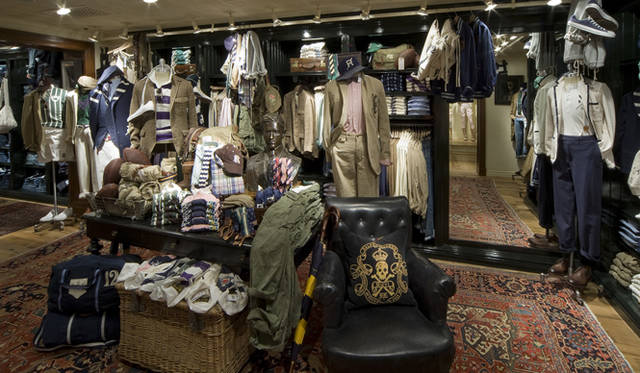 <strong>RUGBY RALPH LAUREN｜ラグビー ラルフ ローレン</strong>　2Fのメンズフロア。籐の籠に詰め込まれたラガーシャツ、ブロンズの胸像やラグビー ラルフ ローレンのロゴが刺繍された重厚なレザーチェアなど、なにかとオトコ心をくすぐるプロダクトでいっぱい。