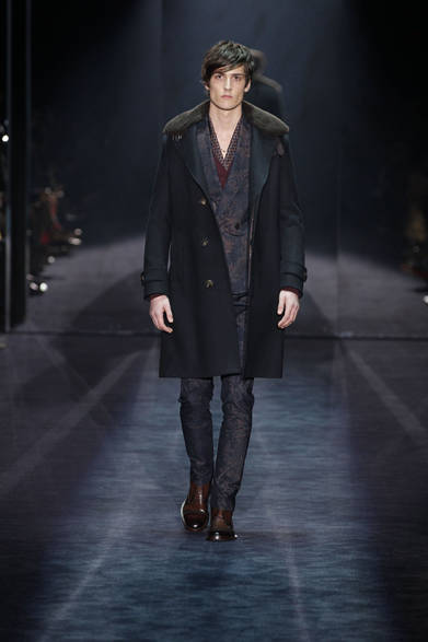 <strong>GUCCI｜グッチ</strong>　ダブルのブレザー、カーディガン、ボックスラインのジャケットは今シーズンのあたらしいスタイル。タペストリープリントやマイクロパターンとともに、デフォルメされたバラやアイリスのプリントが特徴的だ。色は、ダークなニュアンスカラーからデカダンスな雰囲気のレッド、ピーコックグリーンと、カラヴァッジョの絵画のようにドラマチックで強い色調が使われている。パンツは乗馬服からヒントを得たプリーツ入りテーパードスタイル。それにライディングブーツとノーカラーシャツを合わせる。ゆったりとオーバーサイズなシルエットで、「少しだけダンディーな一面をもつ、デビューしたての若いハリウッド俳優のような気負いのないスタイル」とクリエイティブ・ディレクターのフリーダ・ジャンニーニは説明する。