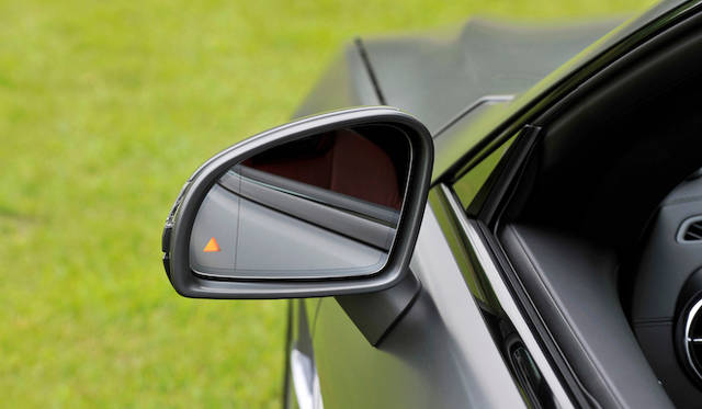 <strong>Mercedes-Benz SL550 BlueEFFICIENCY</strong><br />The triangle on the side mirror is an indicator for the "Active Blind Spot Assist," which illuminates when it detects other vehicles in the blind spot, a feature found on recent Mercedes models.