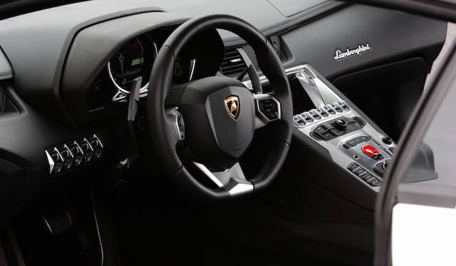 <strong>Lamborghini Aventador LP 700-4</strong><br />Sinking into the incredibly low seat feels like entering a cockpit. The engine start/stop button cover is prominently red on the center console.