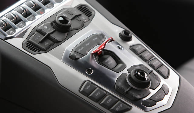 <strong>Lamborghini Aventador LP 700-4</strong><br />The switch to awaken the raging bull is covered by a safety flap to prevent accidental activation. Just above it is the mode selector: 'Strada' for comfort, 'Sport' for sporty driving, and 'Corsa' for track or special conditions.