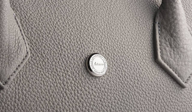 <strong>hinn</strong> Original buttons engraved with messages of 'Honor, Integrity, Nerve, Nonconformity'. The buttons' thickness, exquisite slant, and carving depth were meticulously considered, using a production method with a custom press die, typically not employed for small-lot production. The refined luster from delicate processing and finishing is also a key element that lends elegance to hinn.