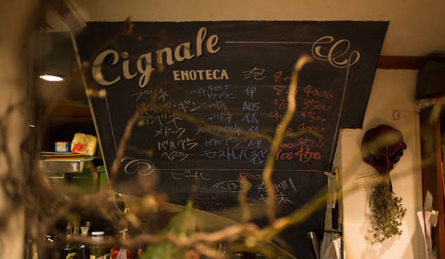 <strong>角田陽太｜東京浪漫酒場</strong>　学芸大学「Cignale Enoteca（チニャーレ・エノテカ）」　厨房の中に建物階段部の下側を利用したドリンクリスト