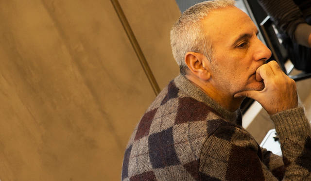 Alessandro Dell'Acqua giving an interview. His classic argyle knitwear is striking.