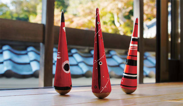 <strong>East Japan Project</strong> 'Stand Up Pen' (Dekoyashiki Daikokuya / MOUNT FUJI ARCHITECTS STUDIO)<br>Inspired by the movements of 'Oshikiri Kokeshi' and 'Aka-beko,' traditional lucky charms and folk toys from Fukushima Prefecture's Aizu region, symbolizing 'falling down seven times, getting up eight' and 'good health.' These charms are the inspiration for a ballpoint pen designed to support Japan's future. Crafted using the 'Hariko' papier-mâché technique, where paper is applied to molds made of wood or clay, these creations are exceptionally light. A weighted interior gives them their unique, wobbly motion. They stand upright on their own, saving space, and their gentle sway creates a delightful scene on any desk. They might even function as an early earthquake detector.