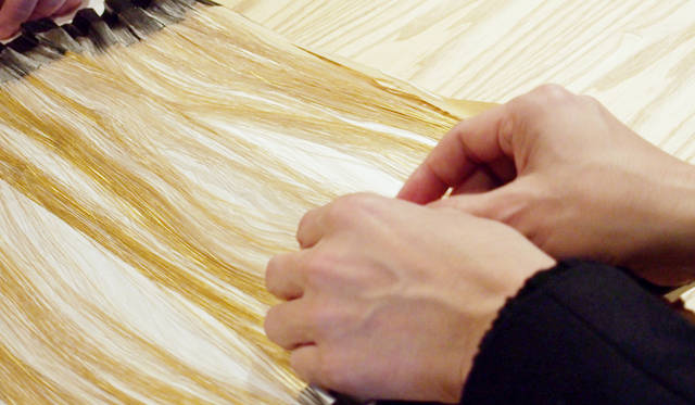 Gold leaf cut to an astonishingly fine thread. Each strand is woven in.