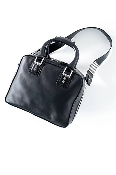 <strong>WOMENS | </strong> With lighter clothing in season, stylist Fukushima recommends balancing a compact outfit with a voluminous bag. The solid design, with its contrasting leather texture and metal hardware, adds a chic, modern accent to any look. [W28×H22×D13cm] Bag ¥110,160 (DIESEL BLACK GOLD)