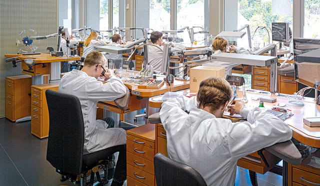 The assembly department of the new manufactory. Natural light streams in through large, open windows.