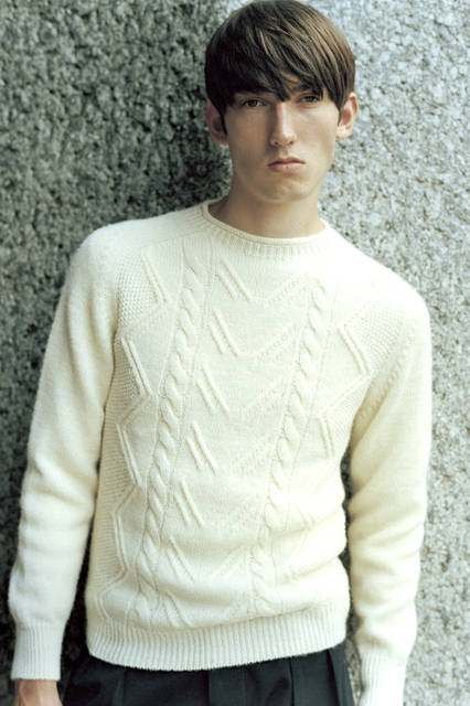 An Aran knit with beautiful cable-knit patterns, offering a refined, voluminous feel. The rustic design provides a comfortable, moderate fit, making it a perfect piece for autumn. Note the slightly high neckline. Knit ¥39,960, trousers ¥35,640 (both Margaret Howell).