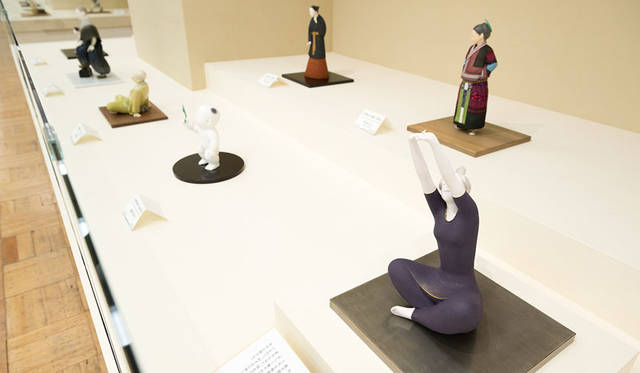 公募展「第62回 日本伝統工芸展」　展示会場<br>（写真右下）日本工芸会会長賞「桐塑彩色「目覚めの刻」（とうそさいしき「めざめのとき」）」〈人形〉井上楊彩