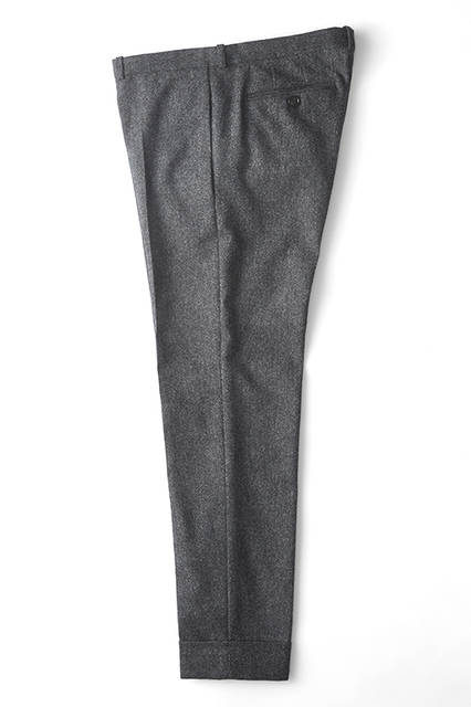 Eight-eighth length wool slacks with a distinctive wide folded hem. The waist is designed with a front-to-back height difference for a立体 fit, and the slim silhouette tapers towards the hem. Effective with dress shoes as well as lace-up boots. Pants ¥51,840 (DIESEL BLACK GOLD)