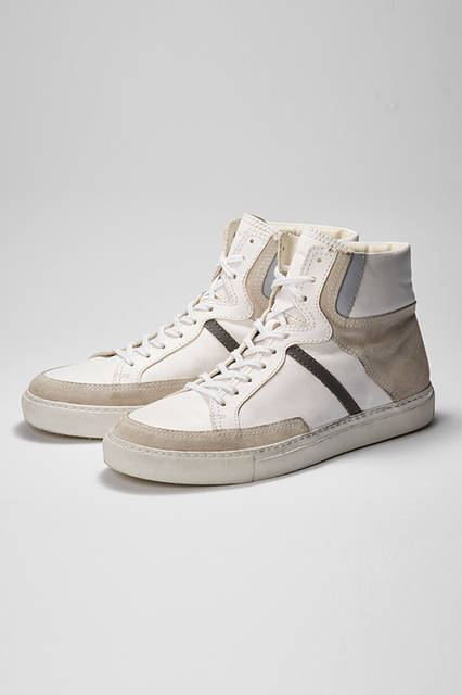 White sneakers offer a touch of effortless cool to edgy casual styles. These high-tops effectively combine different shades of beige, gray, and black. The thick rubber sole and insole also create a leg-lengthening effect. Sneakers ¥72,360 (DIESEL BLACK GOLD)